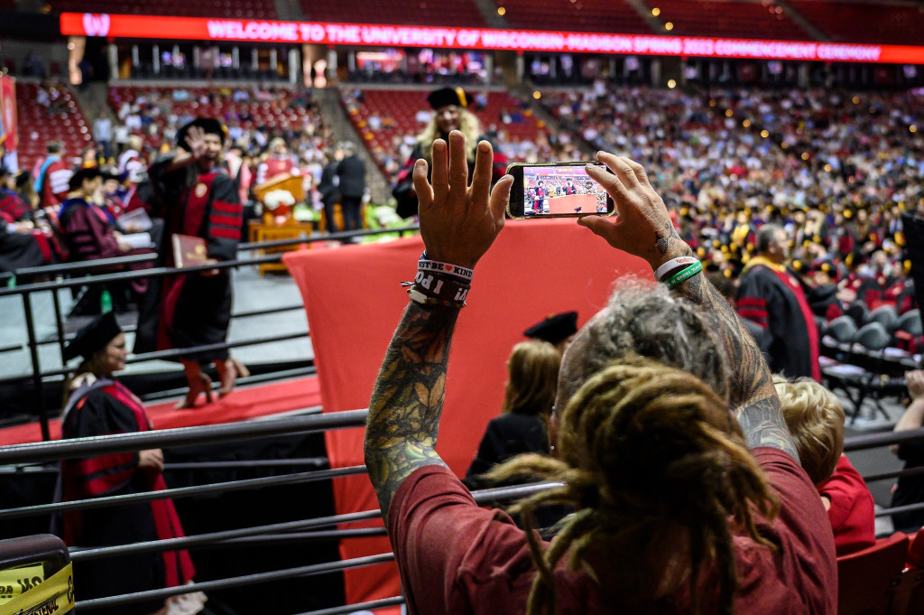 A person crosses the stage, someone else waves to them.