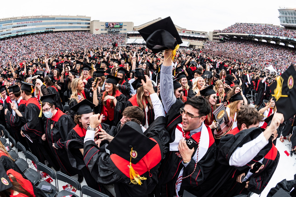 People in commencement robes dance.