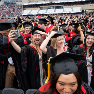 A number of people dance and take selfie photos.