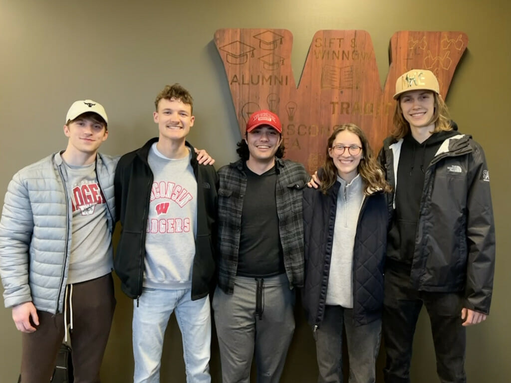 Five people stand and smile for the camera.