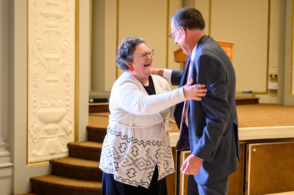 Amy Gillman embraces Karl Scholz in a warm hug.