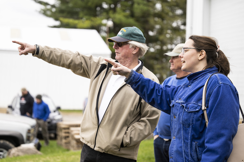 A woman and a man standing next to each other gesture and talk.