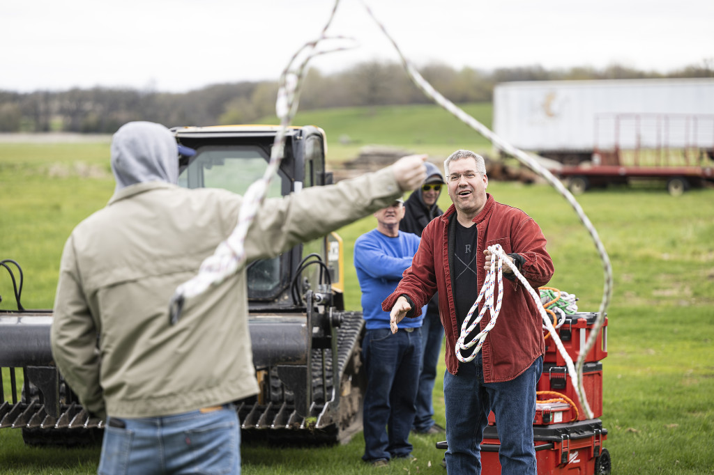 A man ties ropes together.