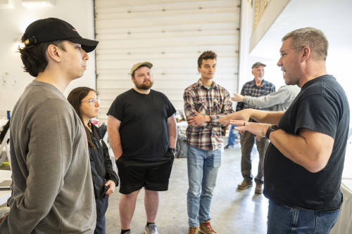 A man talks with a group of students.