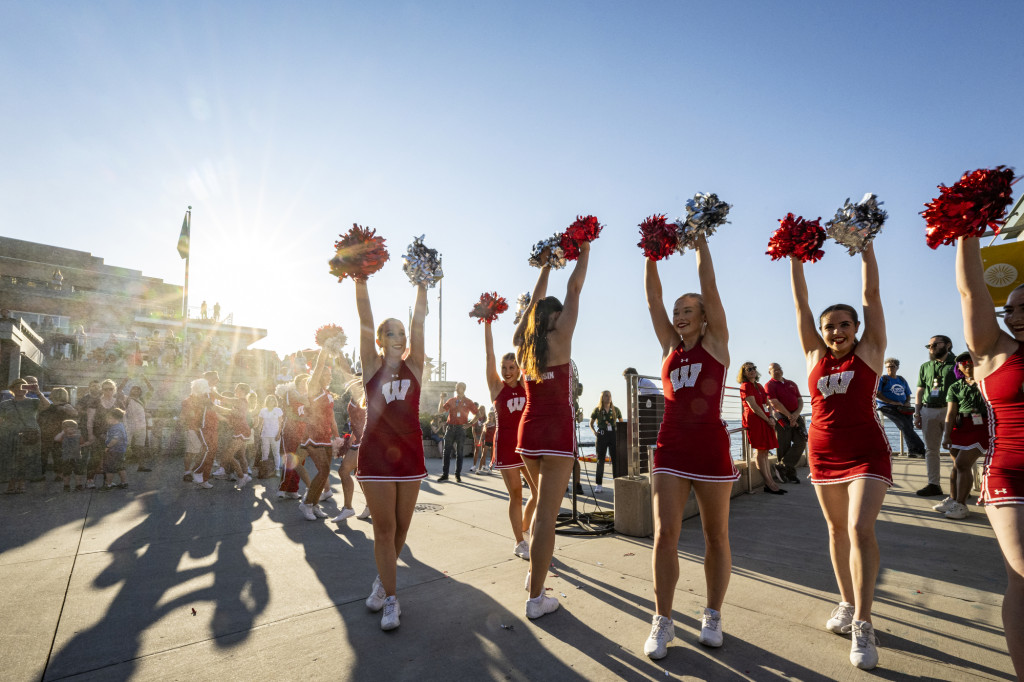 Members of the UW Spirit Squad raise pompoms overhead to liven the crowd.