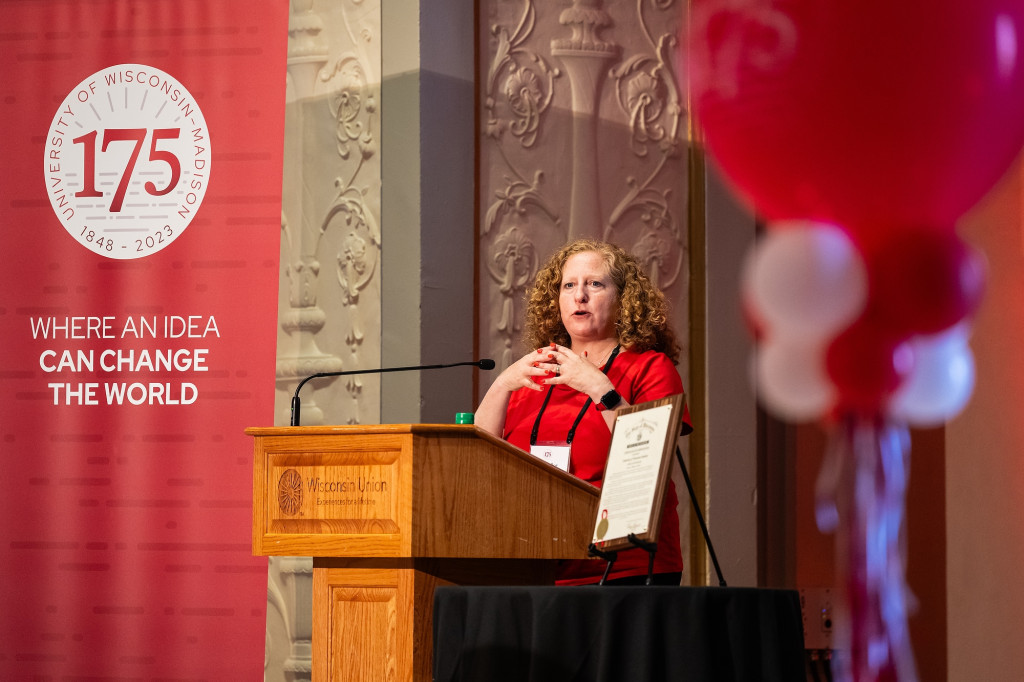 A woman stands at a podium and speaks.