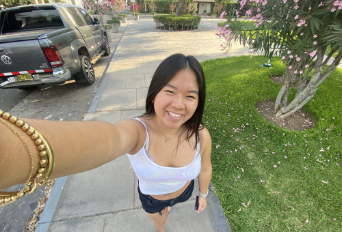 A photo of a woman standing on the sidewalk.