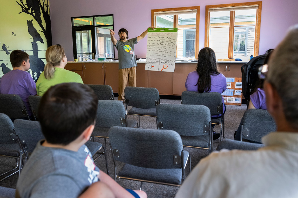 A man talks to a classroom of kids.