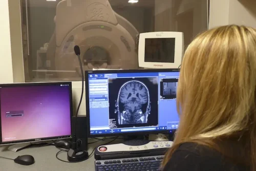 An MRI research technologist at the UW School of Medicine and Public Health reviews research images from a GE MR scanner.