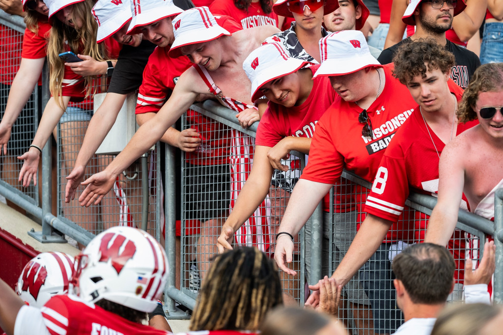 People in the stands lean over to high five players.