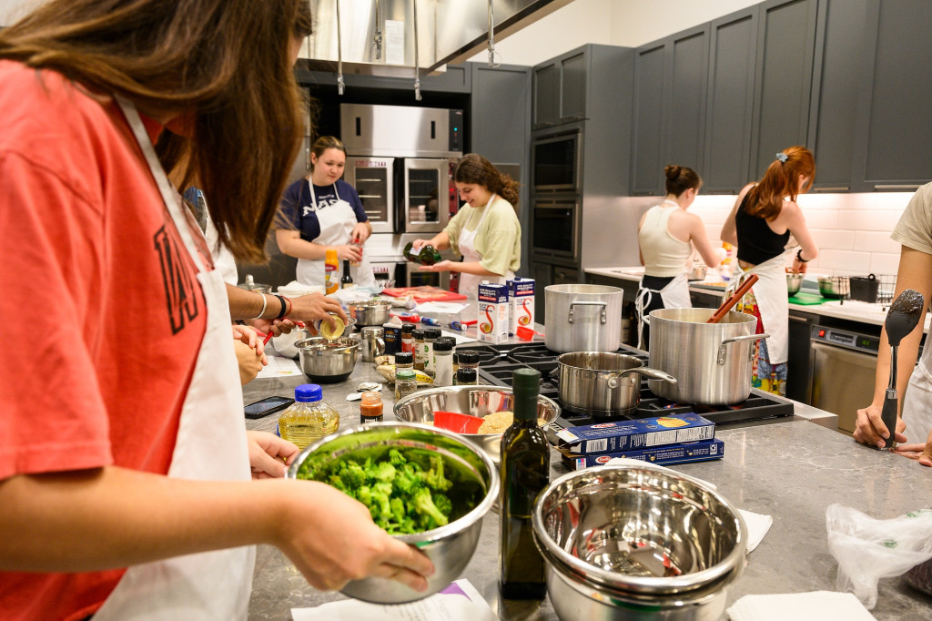 Students work together to cook meals in the  the Wolf Teaching Kitchen.