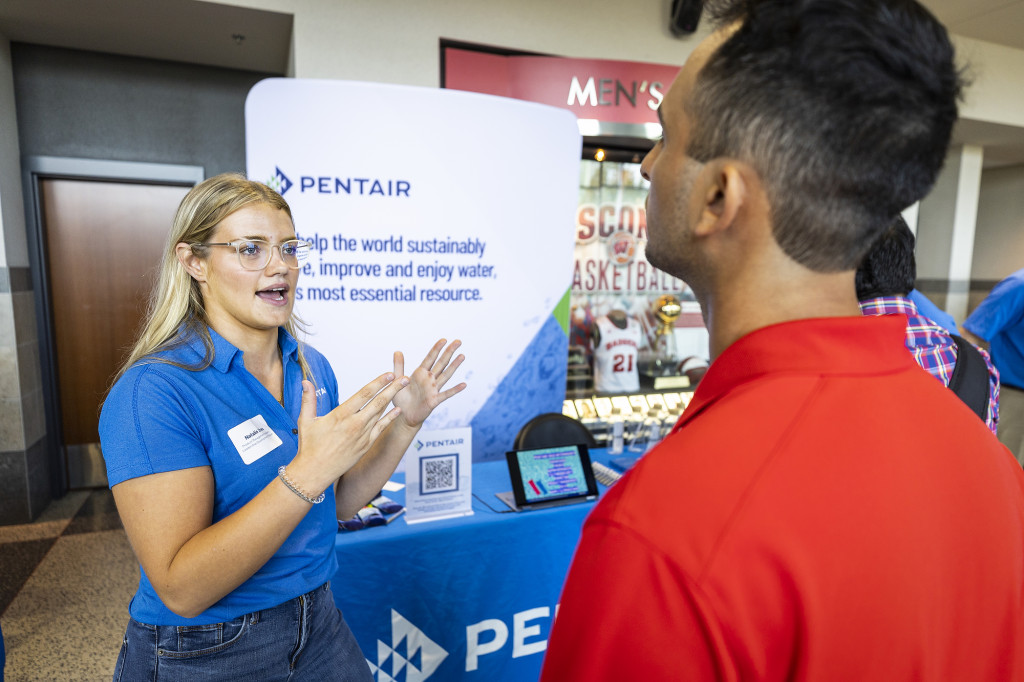 A woman gestures as she talks to a man.