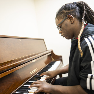 A man sits at a piano and plays.