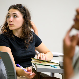 In a classroom, Cerro looks off camera as she listens to a lecture.