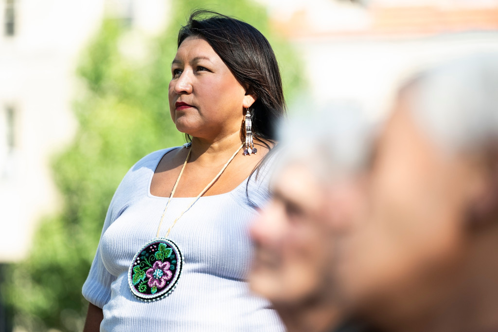 A woman sits and listens.