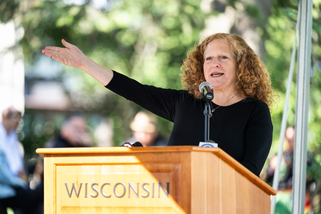 A woman at a podium gestures.