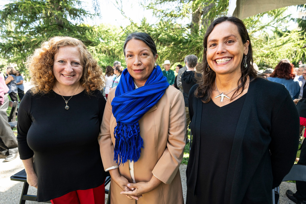 Three women smile for the camera.