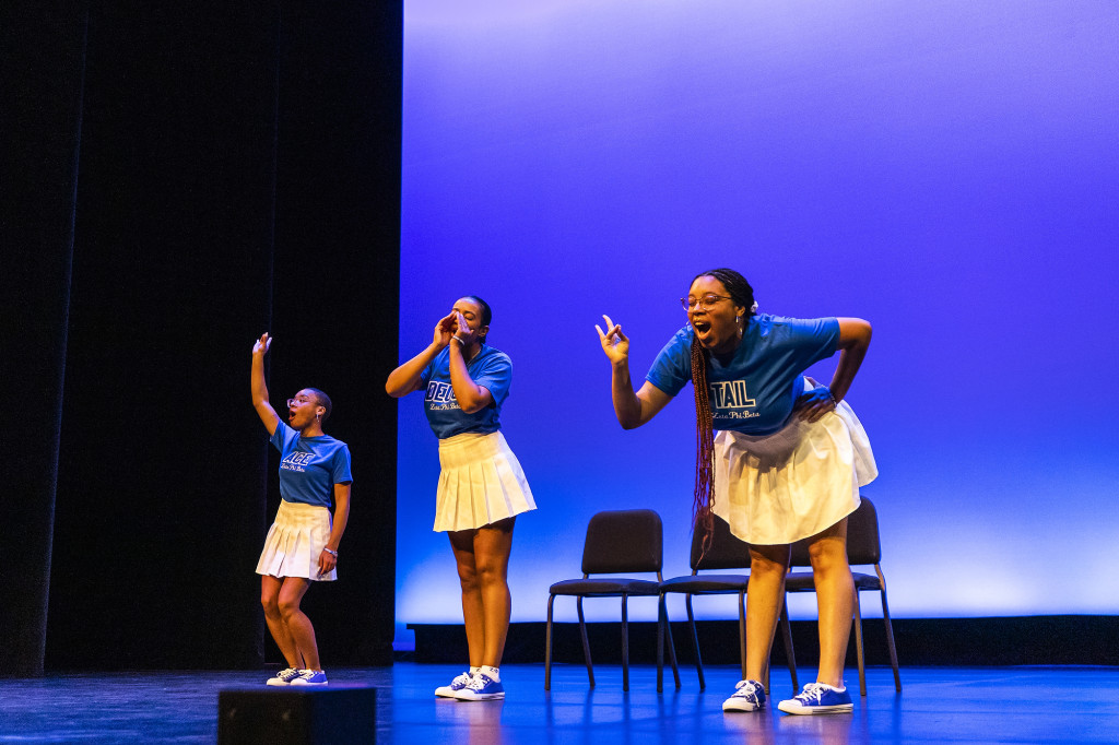 Three women in a line perform.