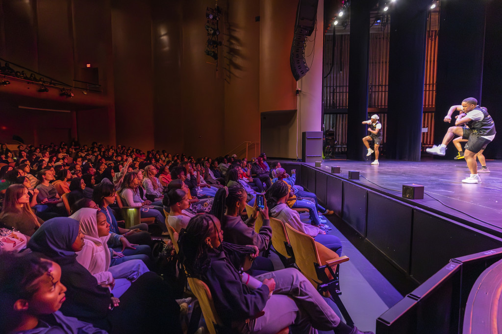 The audience sits in rapt attention as someone performs on stage.