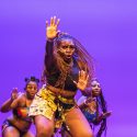 A woman leads a dance on stage.