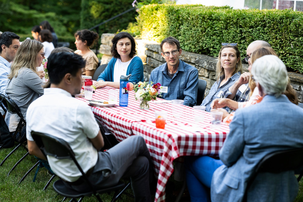 A close-up view of people sitting and eating at a picnic table.