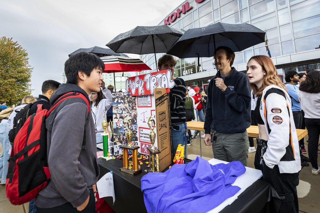 Two people talk next to a booth.