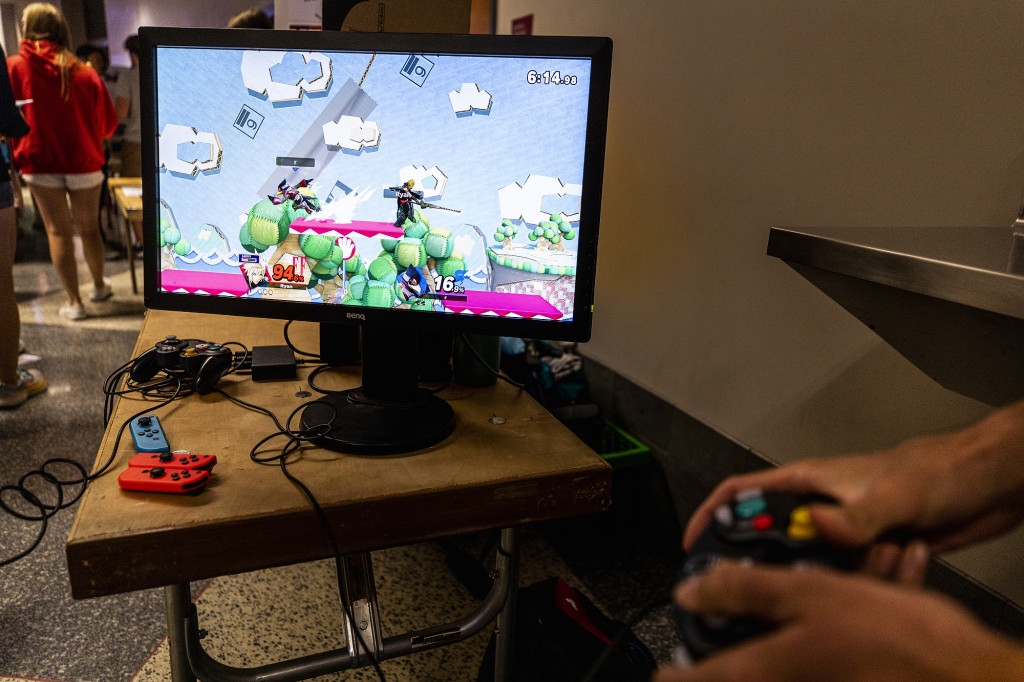 A person holds a game controller while playing a video game.