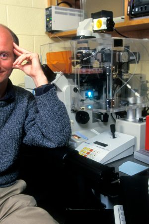 A man sits next to some equipment.