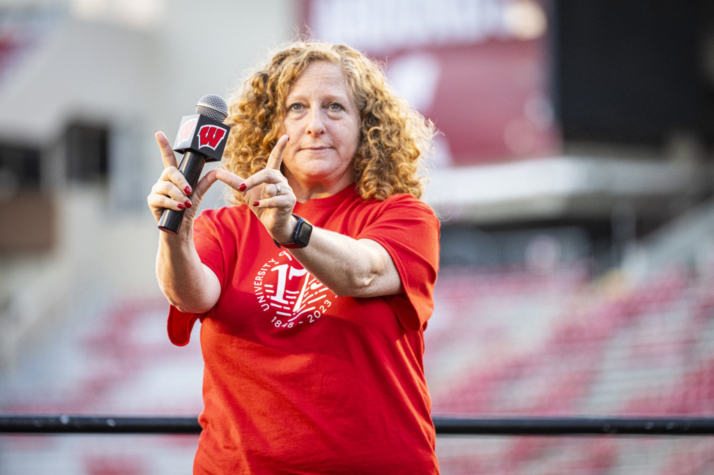 Chancellor Mnookin makes a W sign with her hands while holding a microphone.