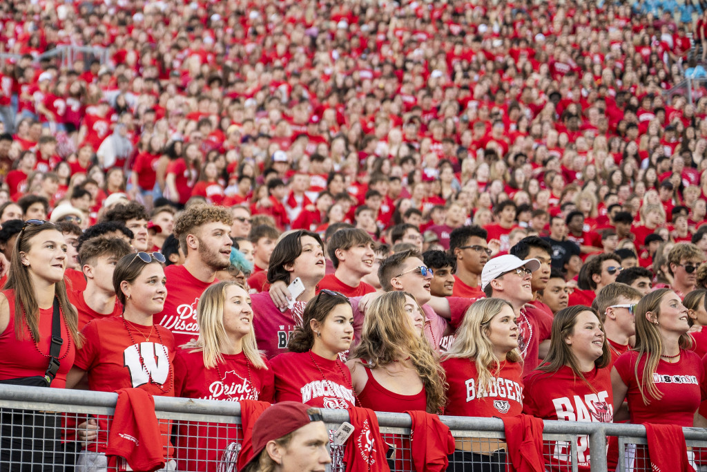 A sea of students in red shirts fills the frame.