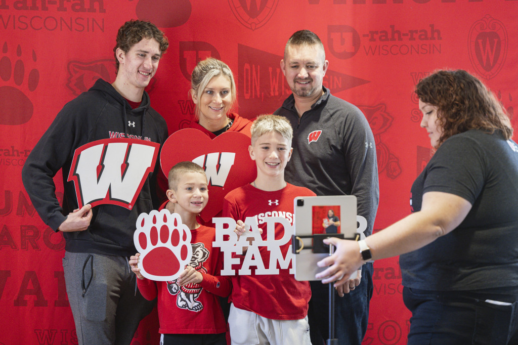 A family huddles together, holding some photo props.