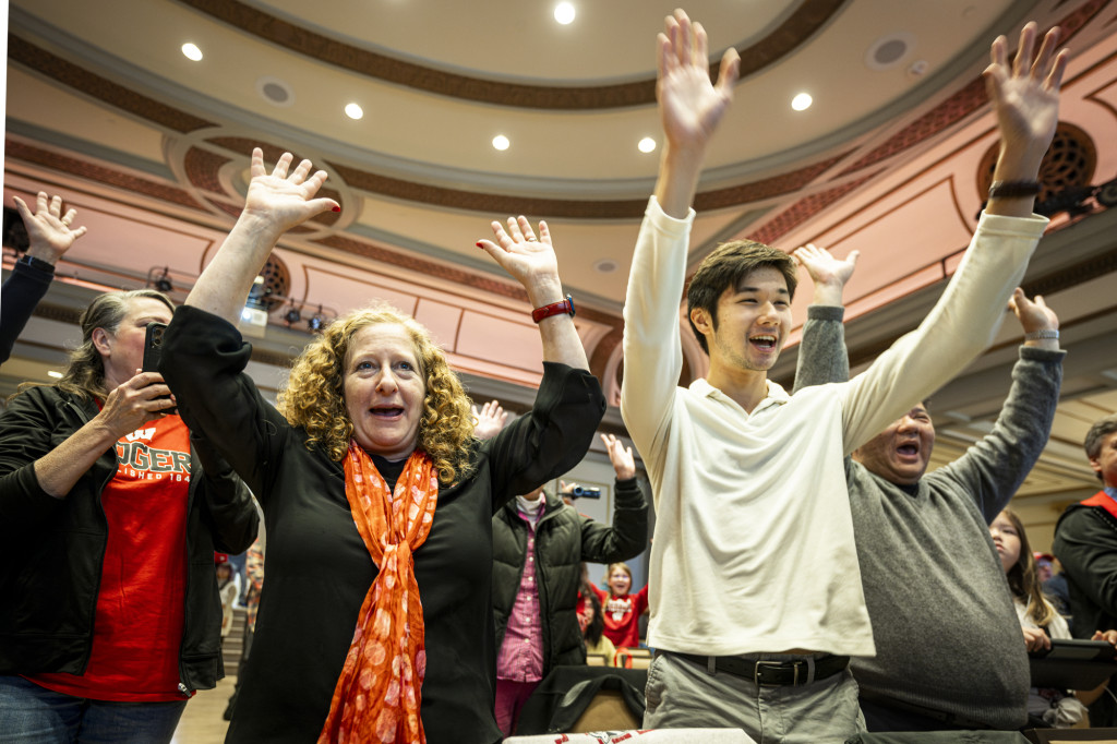 People raise their arms in celebration.