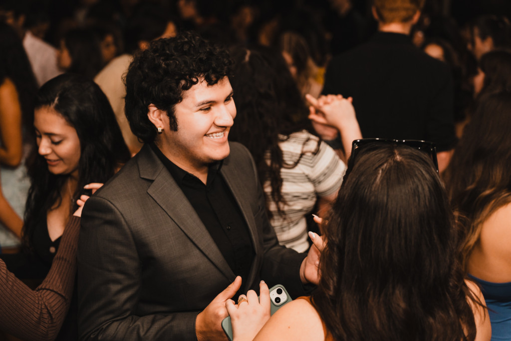 Two students grab each other's hands on the dance floor.