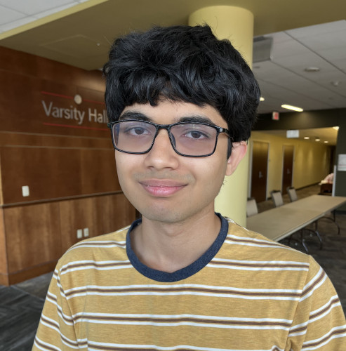 Standing in the corridor outside Union South's Varsity Hall, Paras Kasmalkar smiles for a photo.