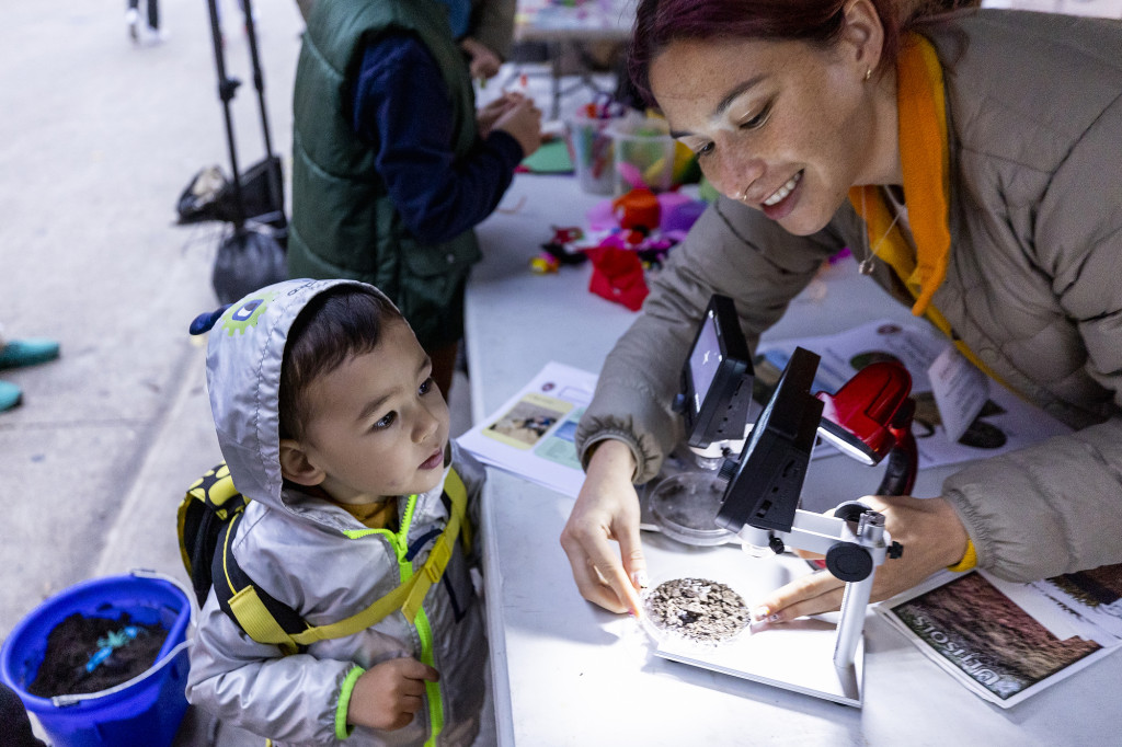 A person shows some worms to a child.