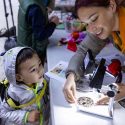 A person shows some worms to a child.