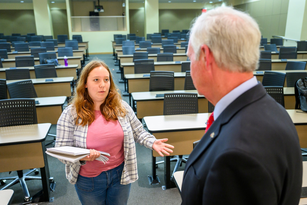 A young woman speaks to a man in a suit.