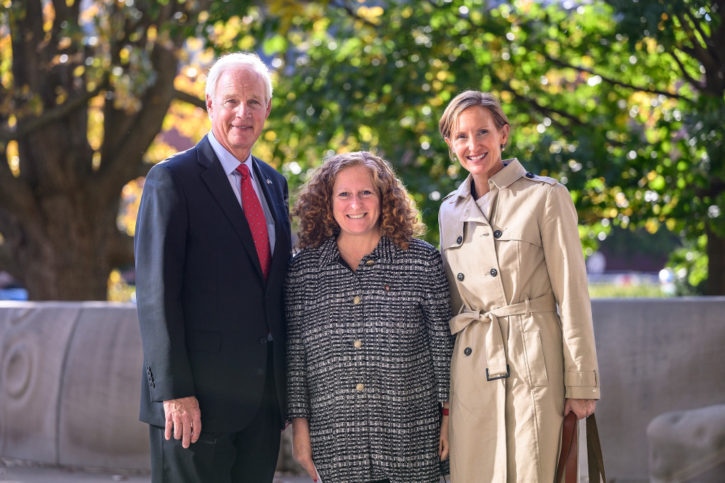 Three people pose for a photo.