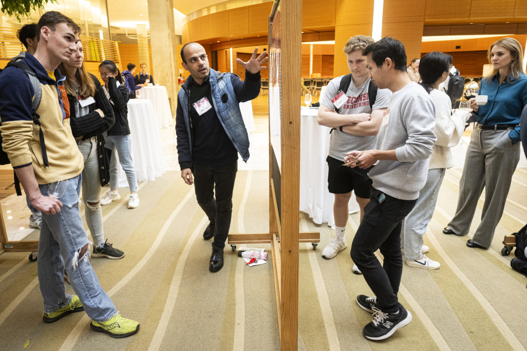 A man talks with others about his posters.