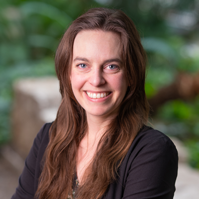 A photo portrait of a woman taken outside in a garden setting