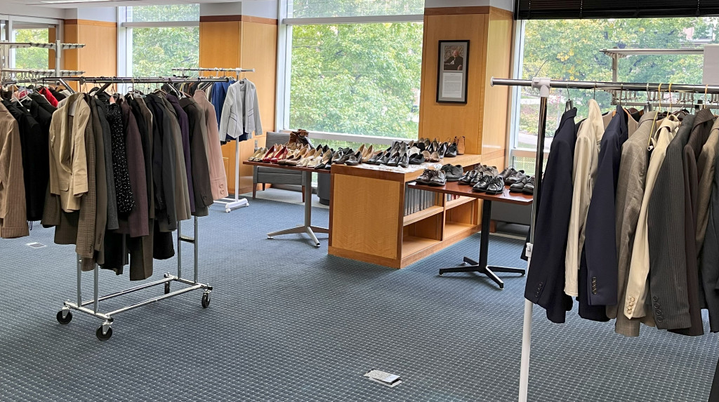 Clothing is displayed on tables and on hangers.