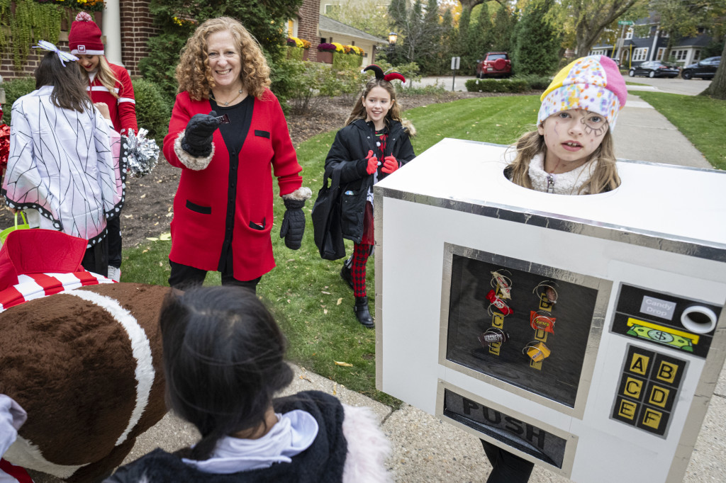 Chancellor Mnookin gets a piece of candy from a trick or treater dressed as a candy vending machine.