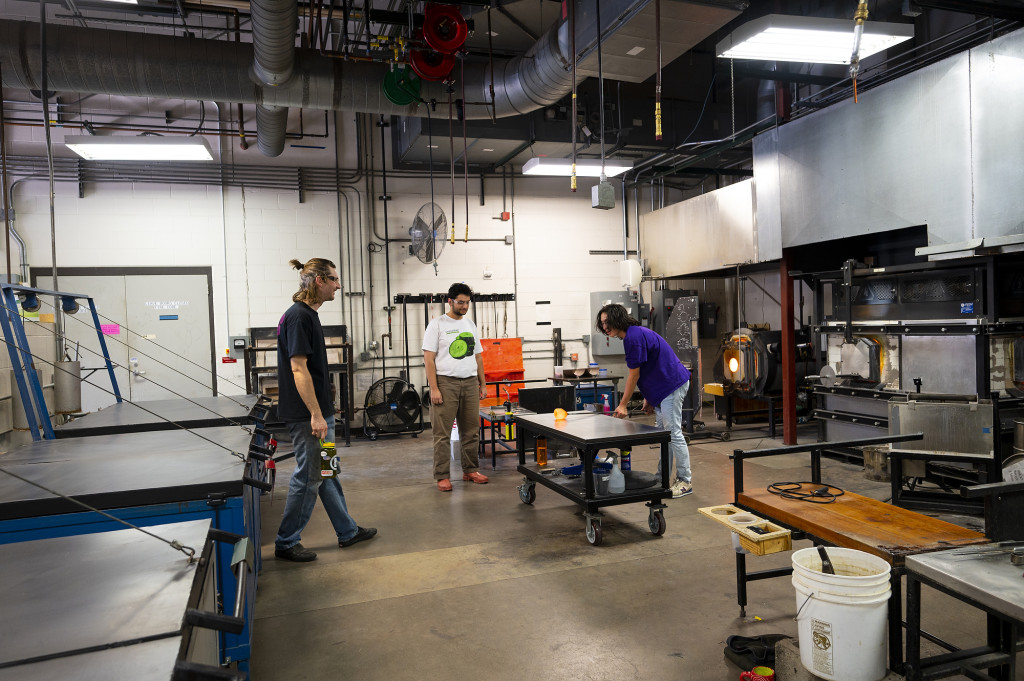 Students work with machinery at a work bench.