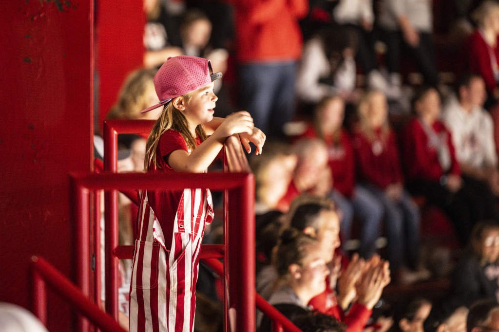 A child watches the game, wonderment on their face.