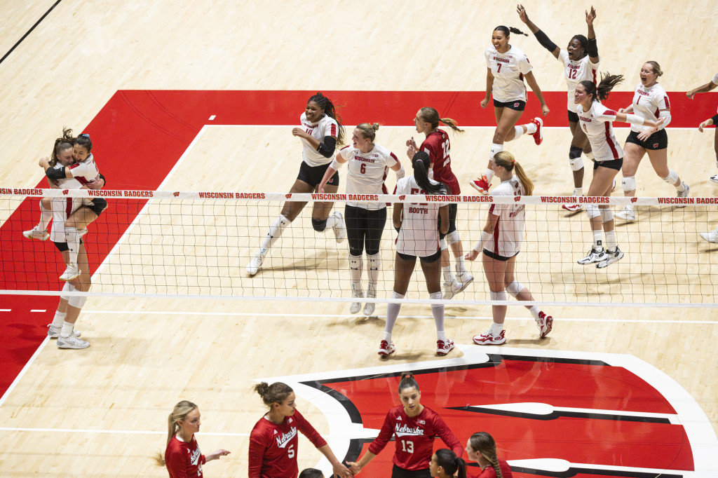 Volleyball players cheer on the court.