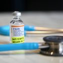 A vial of insulin sits on a table with a stethoscope