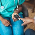 Young nurse doing a glucose blood test on her senior patient, during a home visit. Theme diabetes. The man whose glucose was measured by going to the home of healthcare professionals.