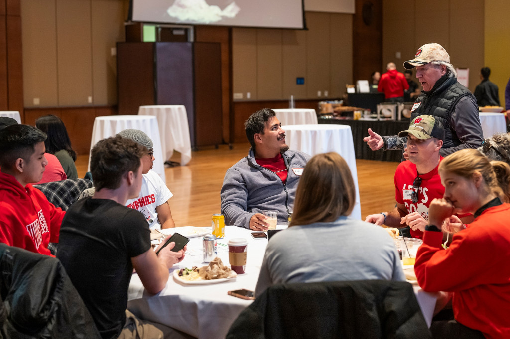 People listen to a speaker as they sit around tables.