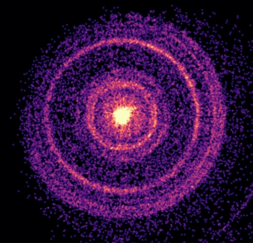 Against a black background, rings of purple and pink converge in a bright, yellow center. It's an image of a bright gamma-ray burst illuminating the Milky Way Galaxy.