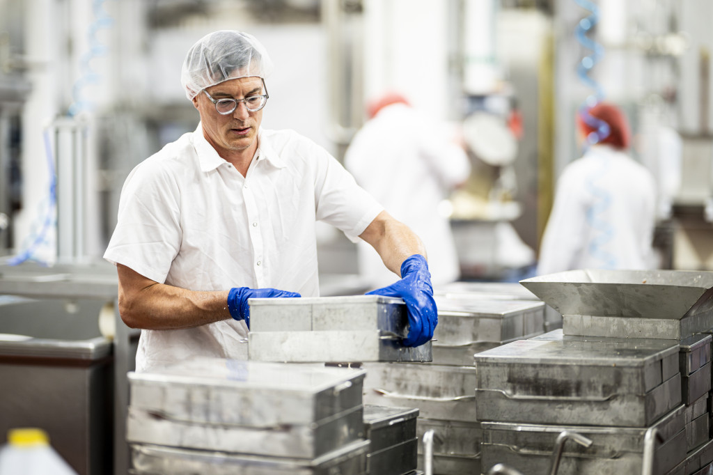 A man stacks some metal forms.